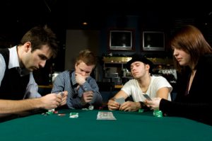 Four friends playing poker together in bar